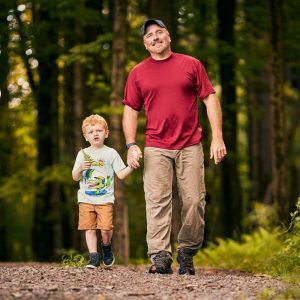Father and son walking through the woods